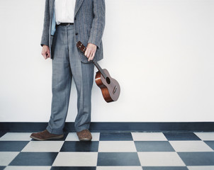 Man in gray suit holding ukelele