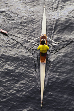 Man sculling in single scull rowing boat