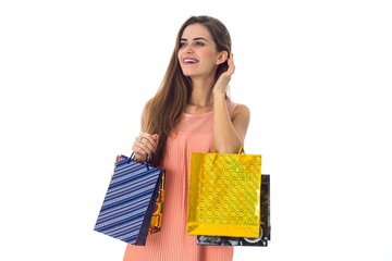 young girl with shopping looks toward isolated on white background