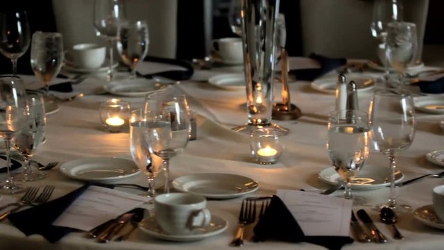 Pan of a set table in a banquet hall.