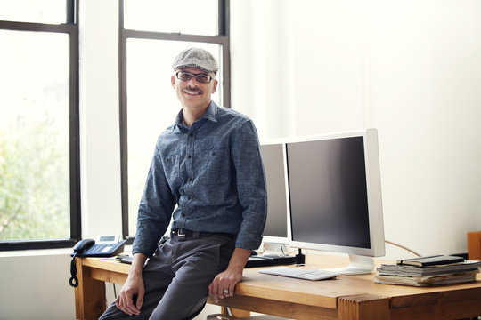 Man sitting on desk in office