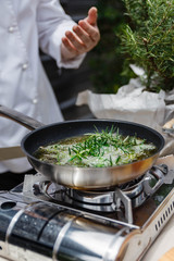 Chef Fried Rosemary Leaves in Olive Oil in a Pan for Making Rosemary Oil.