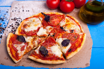 rustic italian pizza with mozzarella, cheese and basil leaves