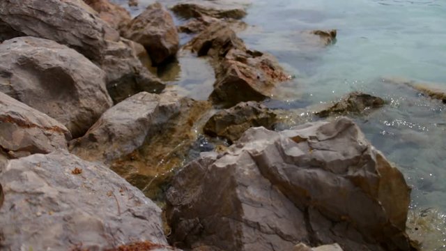 Two close up shots of waves splashing against rocks.