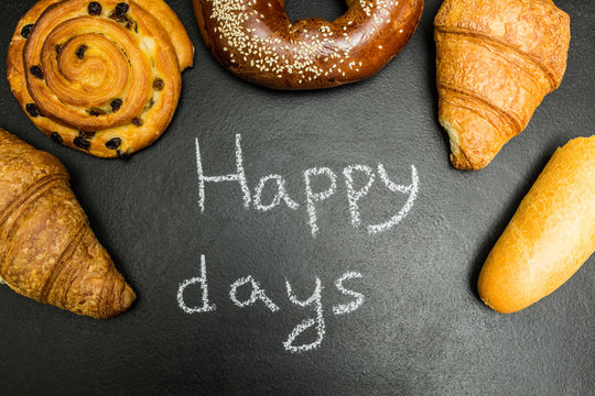 Fresh baked goods on a black background, the words "happy days"