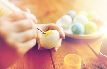 close up of woman hands coloring easter eggs