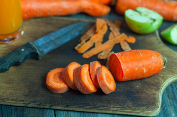 Cut into round slices of carrot on the kitchen brown wooden board