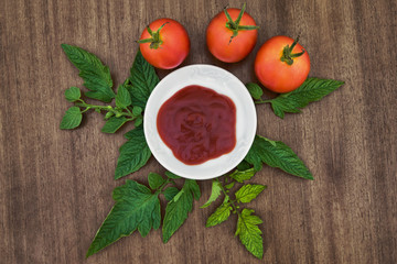 Tomatoes with ketchup on wooden table. Top view