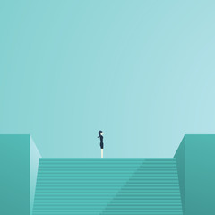 Businesswoman standing on top of stairs as a symbol of business leadership, career success, ambition and achievement.