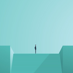 Businessman standing on top of stairs as a symbol of business leadership, career success, ambition and achievement.