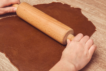 Christmas gingerbread cooking and decoration on the wooden table in the kitchen. Homemade pastries.