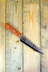 Kitchen knife lying on wooden background