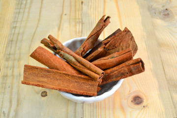 dried cinnamon close up isolated on wooden background