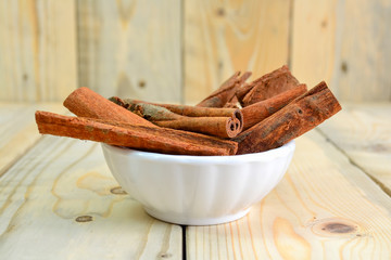 dried cinnamon close up isolated on wooden background