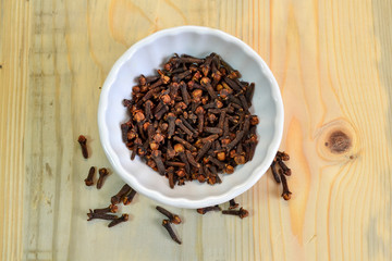 Cloves : Spice in bowl on texture wooden background