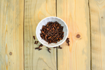 Cloves : Spice in bowl on texture wooden background