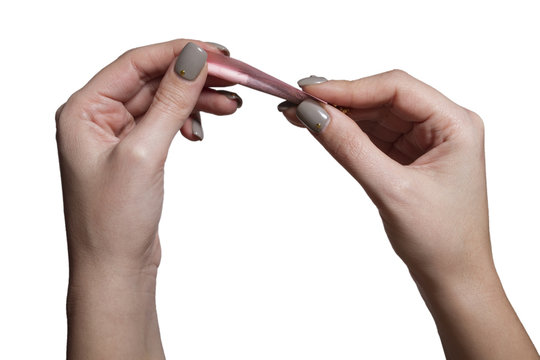 Hands of a woman rolling a cigarette with rolling tobacco on clear background.