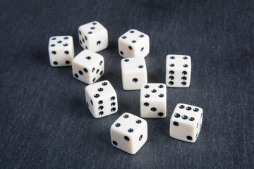 small dice on dark stone background