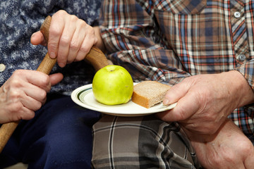 Old couple. Poverty. Apple and bread