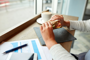 woman eating salmon panini sandwich at cafe