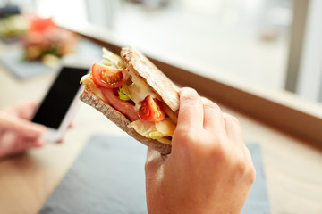 hand with salmon panini sandwich at restaurant - obrazy, fototapety, plakaty