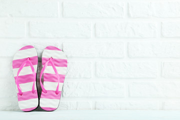 Pair of flip flops on the brick wall background