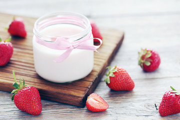 Strawberry yogurt in glass on wooden table