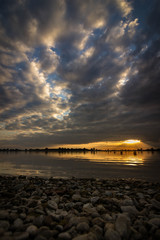 Obraz premium Beautiful sunset with nice clouds at the artificial reservoir emsland, germany.