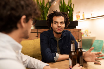 happy male friends drinking beer at bar or pub