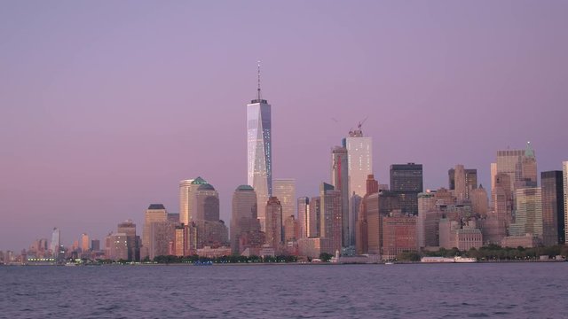 Glow of purple sunrise on the skyscrapers in iconic Downtown Manhattan skyline 