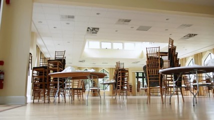 Low angle dolly of a banquet hall before it has been setup for a party.