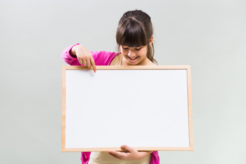 Little girl holding whiteboard.