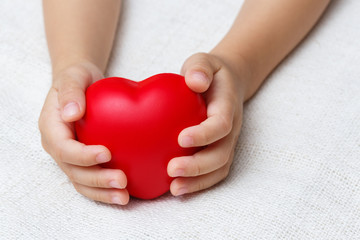 Obraz premium Red heart in baby palm hands