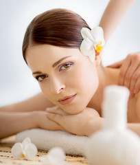 Young and beautiful girl relaxing in Christmas spa salon. Massage therapy, healing medicine and health care concept.