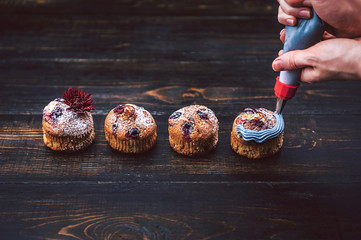 Chef making blueberry cupcakes with cream