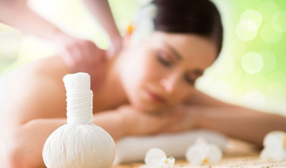Beautiful, young and healthy woman in spa salon. Massage treatment over green summer or spring...
