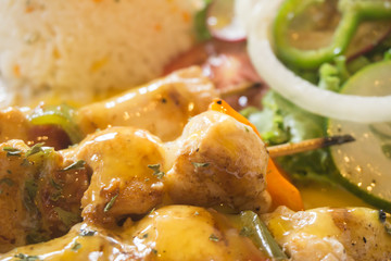 detail of  delicious fish skewers with tropical sauce served on plate. fresh food