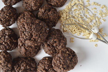 Homemade double chocolate oatmeal cookies with scattered oat flakes and mixer agitator