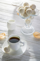 White coconut candies with cup of coffee