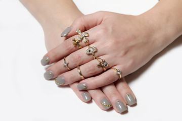 Various gold rings with nice manicured fingernails.