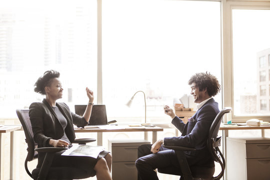 Businessman and businesswoman discussing in office