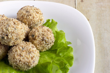 Cheeseballs in white plate on light wood background