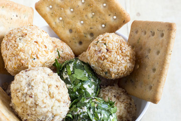 Cheeseballs with crackers on light wood background