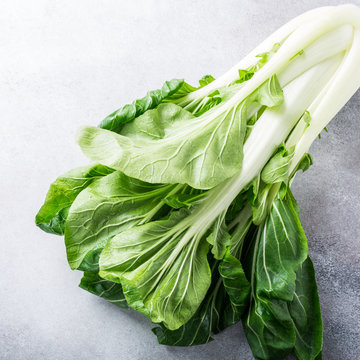 Fresh bok choy, chinese cabbage on gray stone background. Healthy food concept.