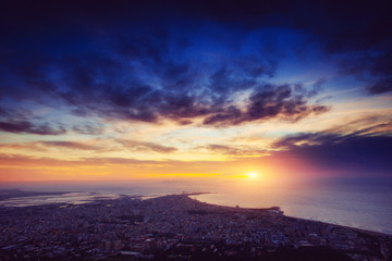 The starry sky above rocky mountains. Fantastic lighting city th