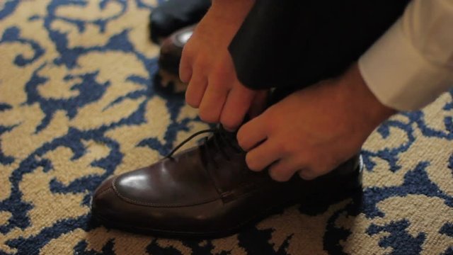 Man ties his dress shoes.