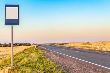 Rural asphalt road with markings and empty information road sign to copy space. Rotate the road.