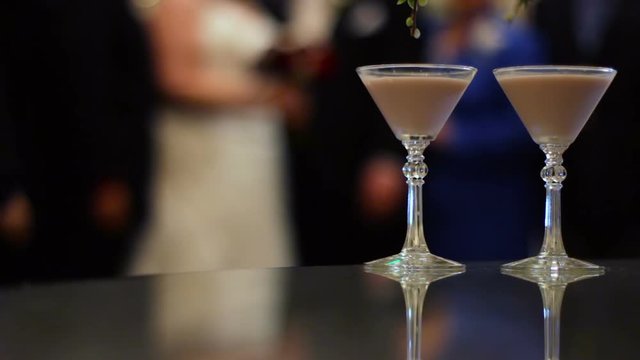 Bride and groom taking pictures, with two martinis in focus in the foreground.