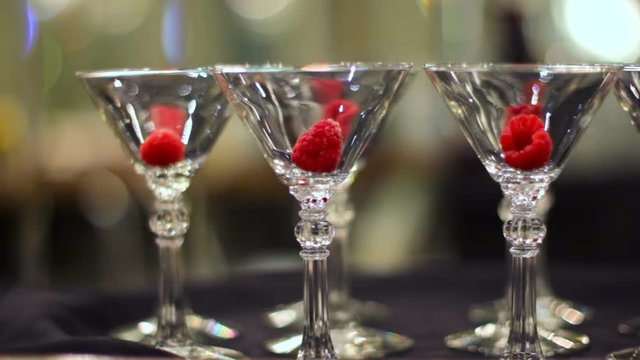 Single raspberry in empty martini glasses.
