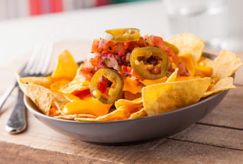 Spicy nachos with chopped onions and tomatoes, jalapeno slices and melted cheese.